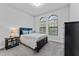 Bedroom with a double bed, dark dresser, and arched windows at 12482 Wild Berry Trl, Odessa, FL 33556