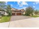 Two-story house with stone accents and a three-car garage at 12482 Wild Berry Trl, Odessa, FL 33556