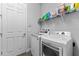 Bright laundry room with washer and dryer, and shelving for storage at 12482 Wild Berry Trl, Odessa, FL 33556