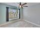 Spacious bedroom with large window, ceiling fan, and gray walls at 14525 Scottburgh Glen Dr, Wimauma, FL 33598