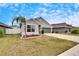 One-story house with gray exterior, two-car garage, and palm tree at 14525 Scottburgh Glen Dr, Wimauma, FL 33598