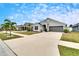 One story house with gray exterior, two car garage, and driveway at 14525 Scottburgh Glen Dr, Wimauma, FL 33598