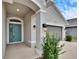 Teal front door entryway with arched detail and light fixtures at 14525 Scottburgh Glen Dr, Wimauma, FL 33598