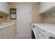 Bright laundry room with washer, dryer, and storage cabinets at 16809 Woburn Ln, Lutz, FL 33549