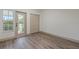 Bright bedroom with wood-look floors and private balcony access at 1946 Hammocks Ave, Lutz, FL 33549