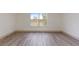 Bright bedroom with wood-look flooring and large window at 1946 Hammocks Ave, Lutz, FL 33549