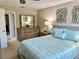 Bedroom featuring a queen bed, dresser, side table with lamp, and patterned curtains at 2217 Sequoia Dr, Clearwater, FL 33763