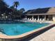 Large community swimming pool with sun loungers and a building with solar panels in the background at 2217 Sequoia Dr, Clearwater, FL 33763