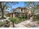 Tan two-story townhome with green metal roof, landscaping, and walkway at 2670 Sequoia Ter # 1406, Palm Harbor, FL 34683