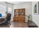 Home office features built-in wooden shelving and hardwood floors at 2721 Tarragona Way, Wesley Chapel, FL 33543