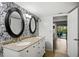 Bathroom with dual vanities, granite counters, and patterned wallpaper at 3006 Mockingbird Ct, Clearwater, FL 33762