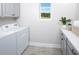 Bright laundry room features modern washer and dryer, ample counter space, and gray cabinets at 31394 Pendleton Landing Cir, Wesley Chapel, FL 33545