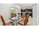 Glass dining table with leather chairs, open to kitchen at 3795 Morgons Castle Ct, Land O Lakes, FL 34638