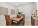 Modern dining room with a wood table, statement wall art, and tiled floor at 3795 Morgons Castle Ct, Land O Lakes, FL 34638