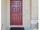 Elegant dark red front door with smart lock and security camera at 3795 Morgons Castle Ct, Land O Lakes, FL 34638