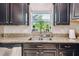 Granite countertops and a double sink are featured in this kitchen at 3795 Morgons Castle Ct, Land O Lakes, FL 34638