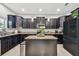 Modern kitchen with dark cabinetry, granite countertops, and an island at 3795 Morgons Castle Ct, Land O Lakes, FL 34638