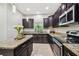 Modern kitchen with dark wood cabinets, granite countertops, and stainless steel appliances at 3795 Morgons Castle Ct, Land O Lakes, FL 34638