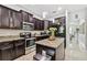 Modern kitchen with dark wood cabinets, granite countertops and stainless steel appliances at 3795 Morgons Castle Ct, Land O Lakes, FL 34638