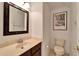 Clean bathroom with toilet, sink, and framed mirror at 402 Islebay Dr, Apollo Beach, FL 33572