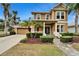 Two-story house with a tan exterior, green accents, and a landscaped yard at 402 Islebay Dr, Apollo Beach, FL 33572