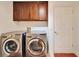 Laundry room with LG washer and dryer and wood cabinets at 402 Islebay Dr, Apollo Beach, FL 33572