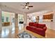 Open living space with red couch, hardwood floors, and views to the kitchen and sunroom at 402 Islebay Dr, Apollo Beach, FL 33572