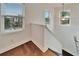 Upstairs hallway with hardwood floors and access to bedrooms at 402 Islebay Dr, Apollo Beach, FL 33572