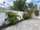 Landscaped backyard with paver patio, privacy fence, and tropical plants at 410 W Lemon St, Tarpon Springs, FL 34689