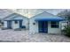 White house with blue awnings and brick paver patio. Two building structures at 410 W Lemon St, Tarpon Springs, FL 34689