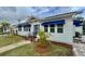 Charming white house with blue awnings and manicured lawn at 410 W Lemon St, Tarpon Springs, FL 34689