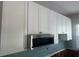 White kitchen cabinets with stainless steel microwave at 410 W Lemon St, Tarpon Springs, FL 34689