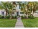 Bright and airy home with a walkway leading to a blue door, surrounded by lush tropical landscaping at 4208 Harbor House Dr, Tampa, FL 33615