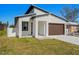 Modern house exterior boasts a clean, white facade, brown garage door, and neatly landscaped lawn at 4351 56Th N Ave, St Petersburg, FL 33714