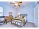 Cozy guest bedroom with a metal bed frame and additional seating at 4439 Devinshire Fields Loop, Plant City, FL 33567