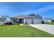 One-story home with gray siding, two-car garage, and landscaped lawn at 4439 Devinshire Fields Loop, Plant City, FL 33567