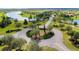 Aerial shot of a well-maintained roundabout showcasing lush landscaping and connecting roads in a picturesque community at 5112 Lake Toscana Dr, Wimauma, FL 33598