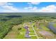 Aerial view of the house nestled in a verdant landscape with a large expanse of trees at 5112 Lake Toscana Dr, Wimauma, FL 33598