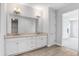 Bathroom showcasing double vanity with granite countertop, tile floors, and a large mirror at 5112 Lake Toscana Dr, Wimauma, FL 33598