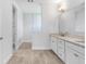 Bathroom featuring double vanity with granite countertop, tile floors, and a framed glass enclosed shower at 5112 Lake Toscana Dr, Wimauma, FL 33598