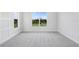 Bedroom featuring neutral walls, a large window providing natural light, and plush gray carpeting at 5112 Lake Toscana Dr, Wimauma, FL 33598