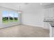 Bright dining room with lots of natural light streaming in through a large window and a modern light fixture at 5112 Lake Toscana Dr, Wimauma, FL 33598