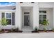 Close up showing front entrance to the home with modern design and manicured landscaping at 5112 Lake Toscana Dr, Wimauma, FL 33598