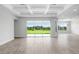 Bright and airy living room featuring tile floors, coffered ceilings, and a large window with outdoor views at 5112 Lake Toscana Dr, Wimauma, FL 33598