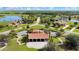 Aerial view of community clubhouse with parking, and surrounding neighborhood with lake and well-manicured lawns at 5214 Lake Venice Dr, Wimauma, FL 33598