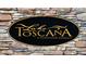 Elegant stone sign for Lake Toscana, a conservation community, set against a textured stone wall at 5214 Lake Venice Dr, Wimauma, FL 33598