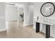 Bright foyer featuring light wood floors, decorative wall trim, and a modern console table with a round mirror at 5214 Lake Venice Dr, Wimauma, FL 33598