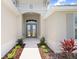 Close-up of a home's entrance with double doors, complemented by landscaped foliage and stylish exterior finishes at 5214 Lake Venice Dr, Wimauma, FL 33598