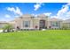 Inviting home exterior featuring a lush green lawn, well-placed shrubbery, and a neutral-toned facade at 5214 Lake Venice Dr, Wimauma, FL 33598