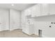 Bright laundry room boasts white cabinets, a utility sink, and washer/dryer hookups at 5214 Lake Venice Dr, Wimauma, FL 33598